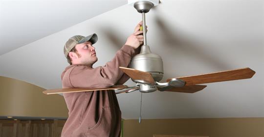 man adjusting ceiling fan